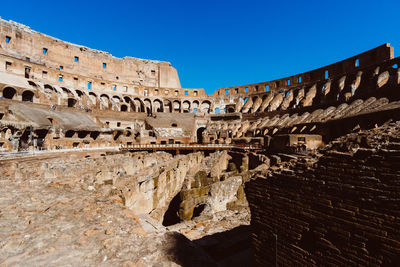 Low angle view of old ruin building against blue sky