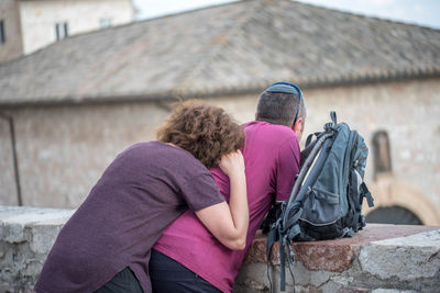 Rear view of people on retaining wall