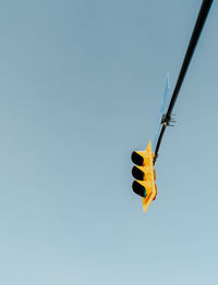 Low angle view of stop light against clear blue sky