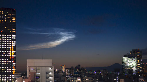 Illuminated city against sky at night