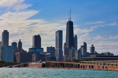 Sea by modern buildings against sky in city - chicago skyline