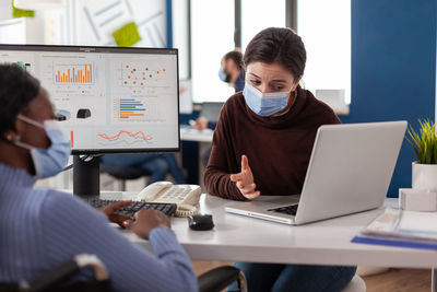 Business colleagues wearing mask working at office