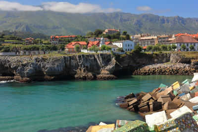 Scenic view of sea by buildings against sky