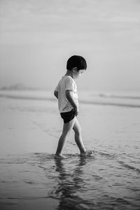 Full length of boy at beach against sky