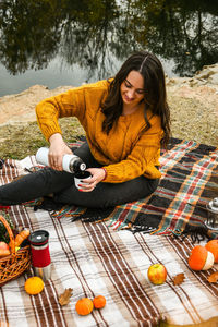 Young woman sitting by orange