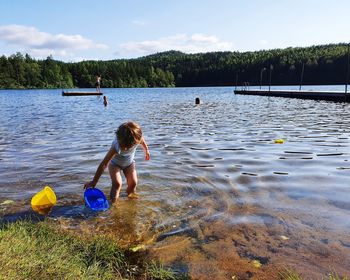 Children in lake against sky