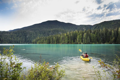 Man paddling inflatable packraft on cheakamus lake, whistler, b.c.