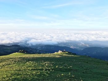 Scenic view of field and mountains against sky