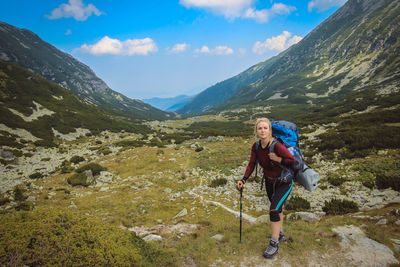 Backpacker looking at view while standing on mountain in forest