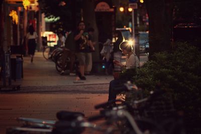 People sitting on road at night
