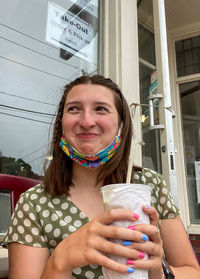 Portrait of a smiling young woman holding drink