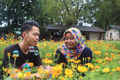 Portrait of a young couple on pink flowering plants