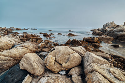 Rocks on beach against sky