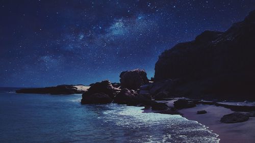 Scenic view of beach against star field