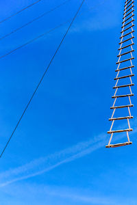 Low angle view of communications tower against blue sky