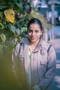 Portrait of young woman standing in city