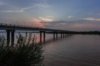 Bridge over river against sky during sunset