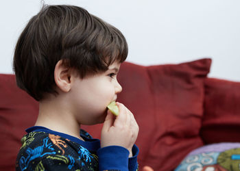 Close-up of boy eating food at home