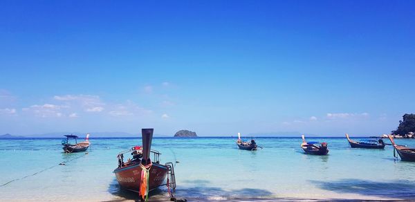 View of boats in sea against blue sky