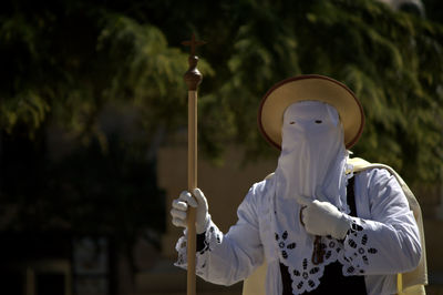 Man wearing traditional clothing walking on street during easter