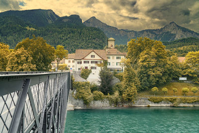 Scenic view of river by buildings against sky