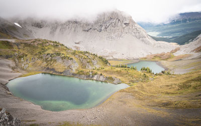 View on two alpine tarns shrouded by clouds, mount smutwood trail in kananaskis, alberta, canada