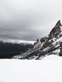 Snow covered land and mountains against sky