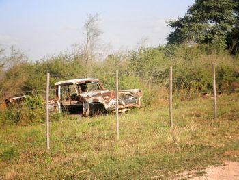 Abandoned truck on field against sky