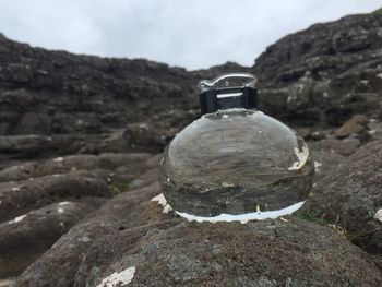 Close-up of water on mountain against sky