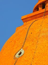 Low angle view of cross against orange sky