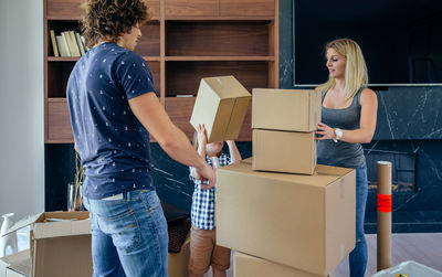 Parents with son unpacking boxes at home