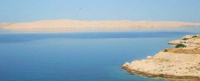 Scenic view of sea with mountain range in background