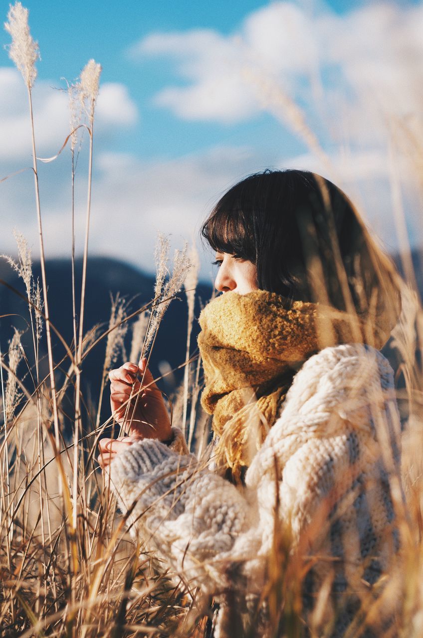 one person, sky, real people, nature, child, leisure activity, plant, childhood, lifestyles, land, day, selective focus, cloud - sky, field, warm clothing, young adult, side view, winter, clothing, outdoors