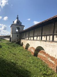 Arch bridge and old building against sky