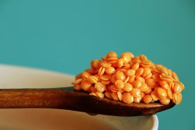 Close-up of red lentils on wooden spoon