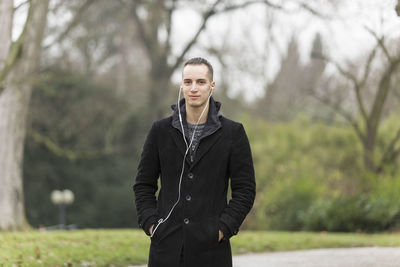 Portrait of man standing against trees