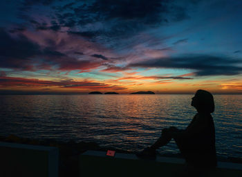 Silhouette man on beach against sky during sunset