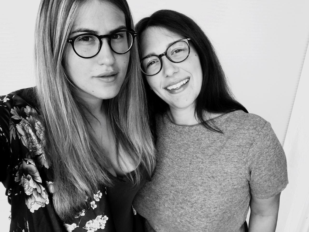 eyeglasses, looking at camera, portrait, two people, smiling, real people, teenage girls, happiness, togetherness, teenager, long hair, glasses, front view, casual clothing, lifestyles, young adult, standing, bonding, cheerful, young women, day, friendship, indoors, close-up, people