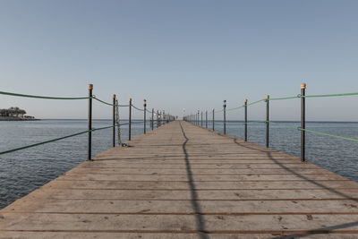 Pier over sea against clear sky