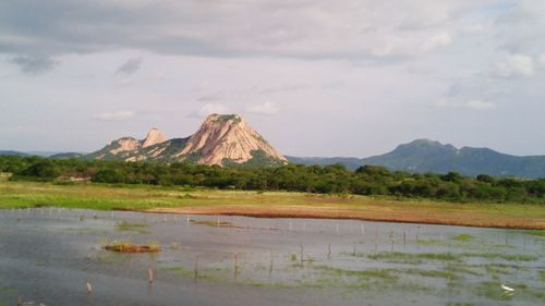 Scenic view of mountains against cloudy sky