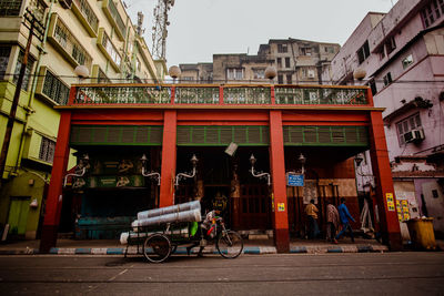 People on street against buildings in city