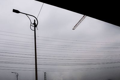 Low angle view of electricity pylon against sky