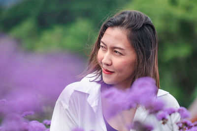 Woman amidst purple flowers looking away