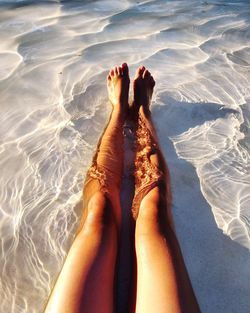 Low section of woman relaxing in swimming pool