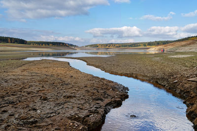 View to the dam wall of a dam with low water level, the dryness is visible, after a hot summer