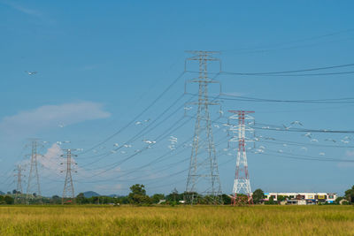 Electricity pylon on field against sky