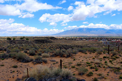 Scenic view of desert landscape against cloudy sky
