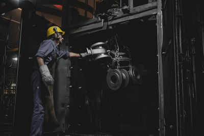 Man working over metallic machine in industry