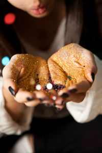 Close-up of woman with glitters in hand