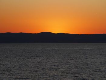 Scenic view of sea against orange sky